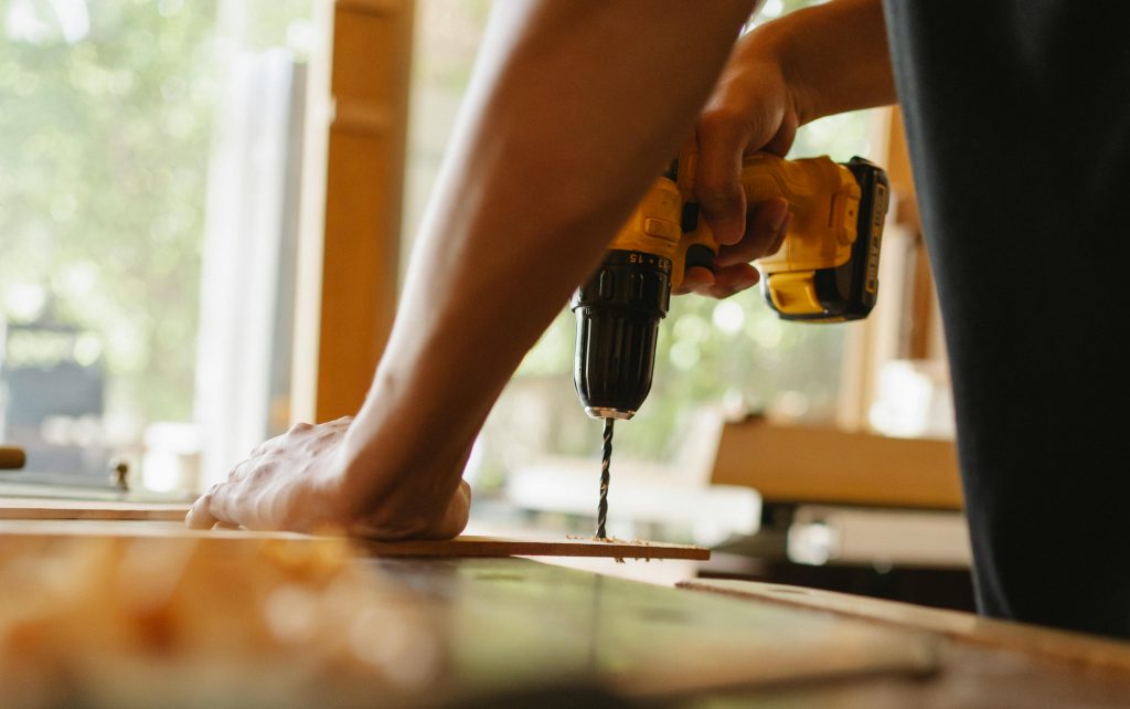 pexels-photo-5974053-5974053 Man drilling wooden plank on desk